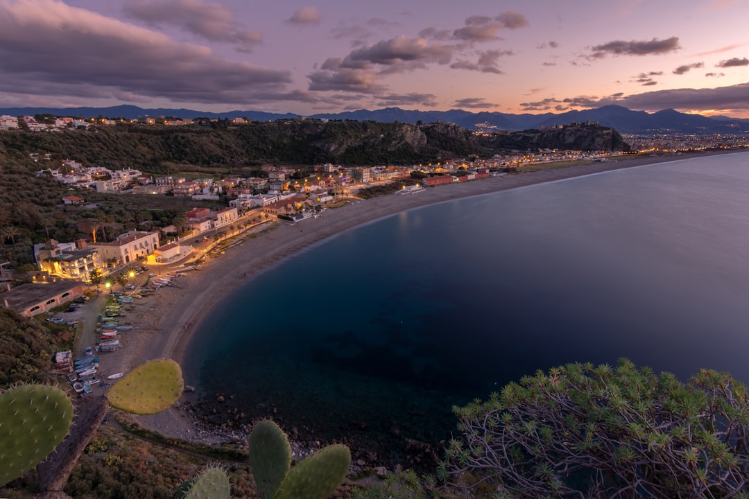 Coastal town illuminated at dusk with calm sea